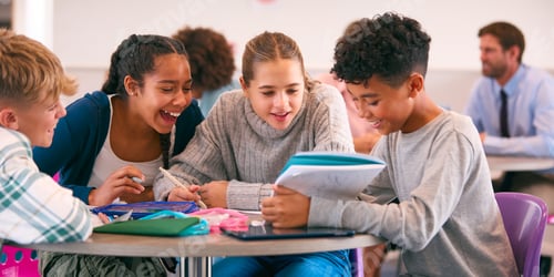 Preview: Secondary Or High School Students Collaborating In Study Area With Teachers In Background
