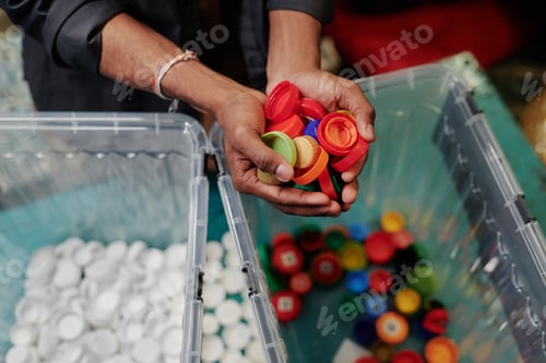 Preview: Holding heap of multicolor bottle caps