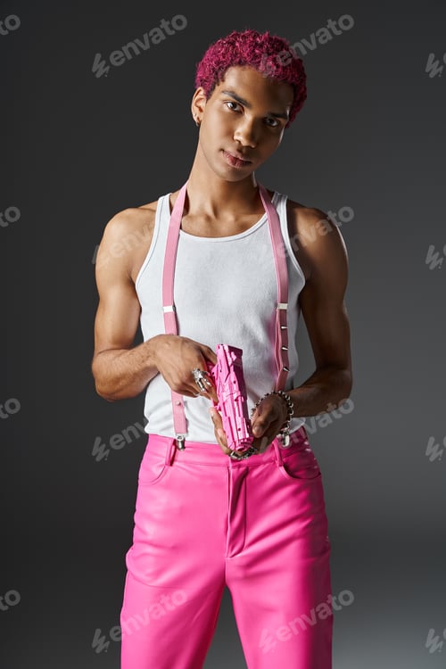 Preview: handsome pink haired male model with silver accessories and pink suspenders holding pink toy gun