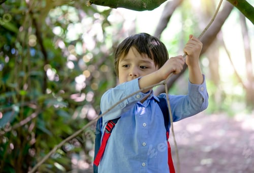 Vista previa: Niño sosteniendo palo de madera el parque. niño llevando mochila jugando al aire libre en un día soleado Verano