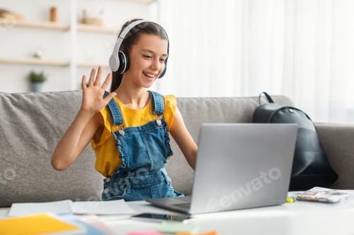 Preview: Girl in headphones using laptop, waving hand to webcam