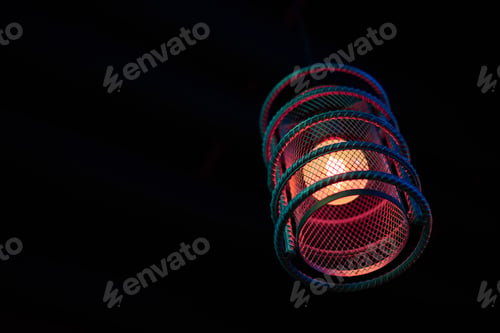 Preview: Loft pendant lamp with red blue glow in steel rebar shade, wooden interior background, copy space
