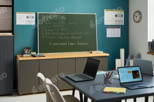 Preview: Empty Classroom with Laptops and Blackboard Displaying AI Prompting Instructions