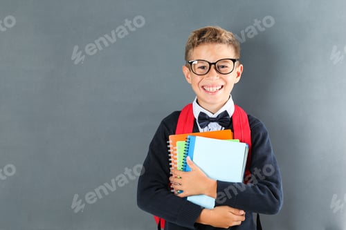 Preview: Boy in school uniform with copybooks against board, space for text