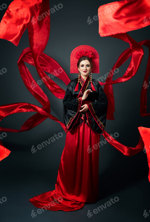 Preview: Woman is dressed in red Chinese Japanese folk clothing. Flying fabric, beautiful