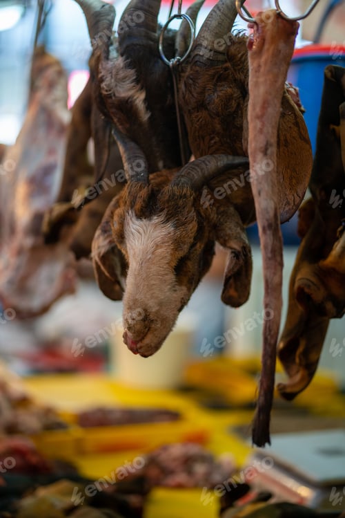 Preview: Closeup shot of a goat heat hanging from a hook in a butcher's stall