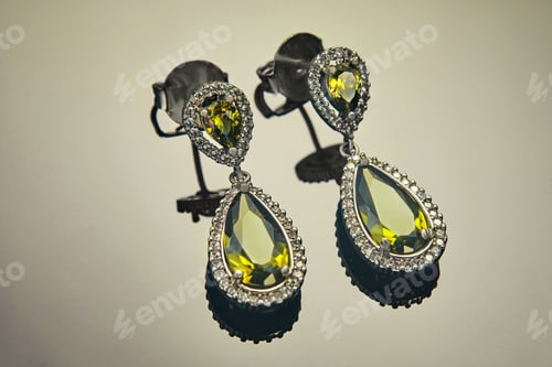 Preview: White gold earrings with diamonds and yellow-green stones on a gradient background with reflection