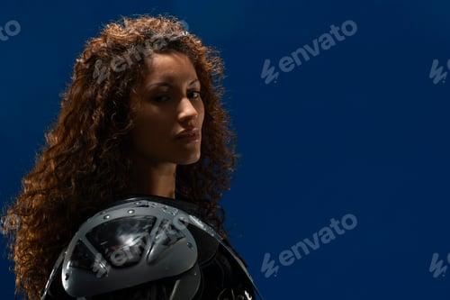 Preview: Portrait of young woman wearing american football shoulder pads