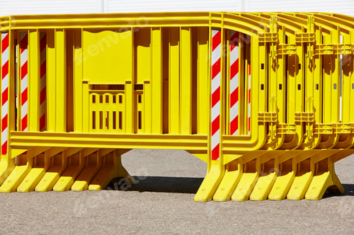 Preview: Yellow plastic barrier fence over an asphalt road. Security