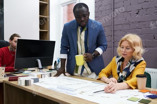 Preview: Business people drawing blueprint in team