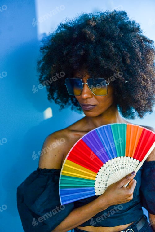 Preview: Fashionable woman with a colorful fan, big afro hair, and stylish sunglasses