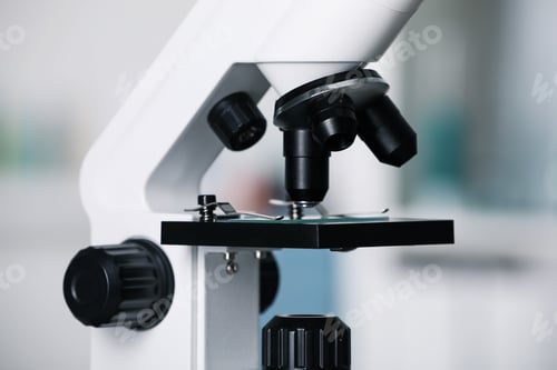 Preview: Modern medical microscope with glass slide on blurred background, closeup