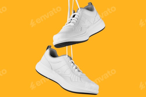 Preview: Pair of white male sneakers on yellow background. Stylish shoes isolated