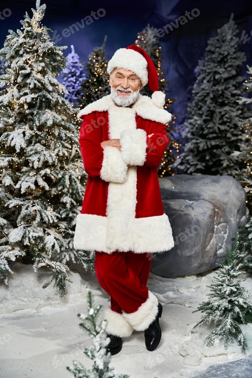 Preview: Cheerful Santa Claus wearing a red suit stands in a snowy forest with festive decorations