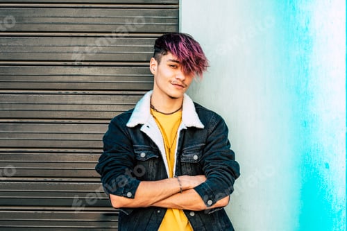 Preview: One young guy sitting outdoor with city buildings in background looking on camera with trendy hair