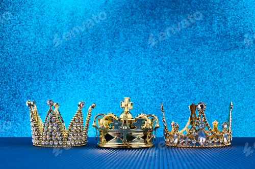 Preview: Epiphany Day or Dia de Reyes Magos concept. Three gold crowns on blue sparkling background