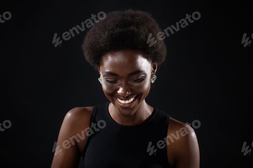Preview: Young black positive african american woman laughing portrait on black background