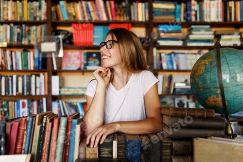 Preview: Young smiley woman or girl in bookstore or library