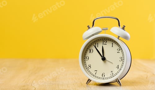 Preview: Round white alarm clock, the time is five minutes to twelve. Yellow background