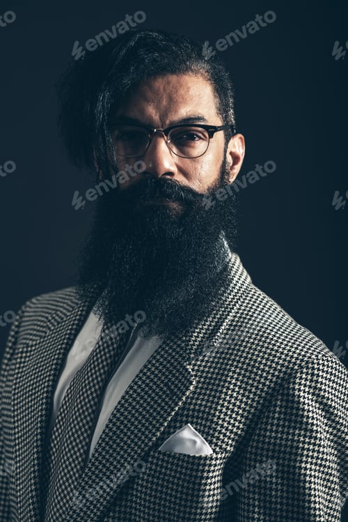 Preview: Dark Moody Portrait Of A Man With A Big Bushy Beard Wearing Glasses And A Stylish Checked Suit
