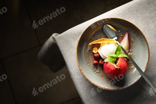 Preview: Ice cream and pear in wine on plate and spoon on light background, space for text