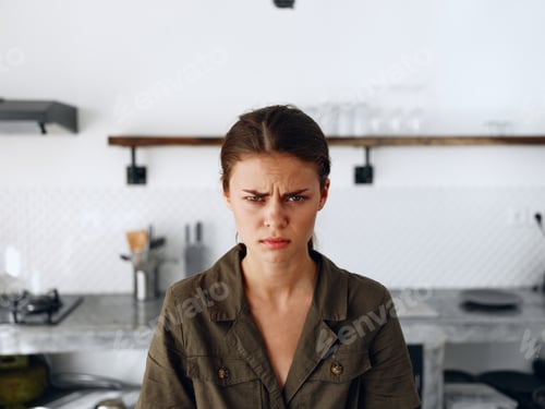Preview: Portrait of a sad tired woman with a sore head in the kitchen, domestic problems, unstable emotional