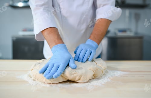 Preview: Baker man kneading dough and bakery ingredients. Bakery concept