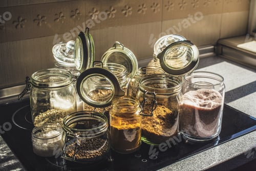 Preview: Close up shot of transparent jars of oats, salt, lentils, honey, rice, turmeric and panela