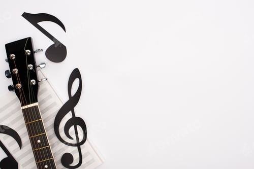 Preview: Top view of paper cut notes, music book and acoustic guitar on white background