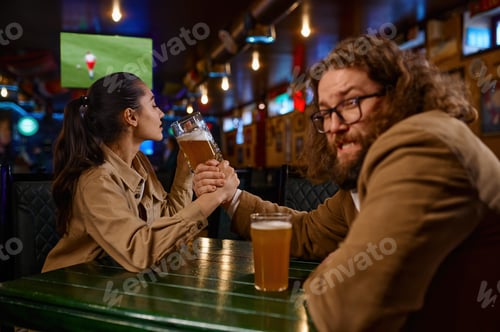 Preview: Arm wrestling challenge between man and woman at pub