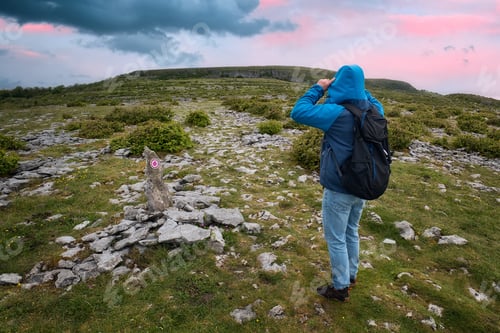 Preview: Beautiful sunrise landscape scenery with man hiking on top of mountain at Farm loop trail at Burren