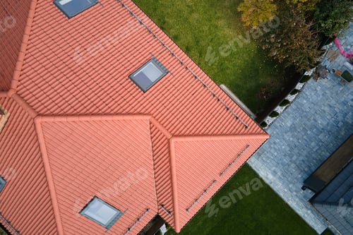 Preview: Closeup of attic windows on house roof top covered with ceramic shingles. Tiled covering of building