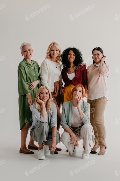 Preview: Multi-ethnic group of mature women bonding and smiling against grey background
