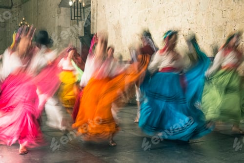 Preview: Blurred view of women dancing in traditional costumes, with bright coloured skirts