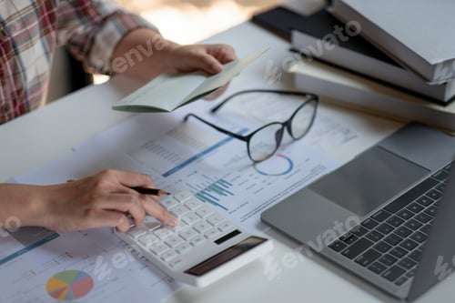 Preview: woman checking amount in bank account passbook with bank statement. Accountant using calculator for