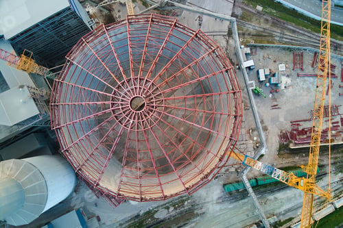 Preview: Aerial view of cement factory under construction with high concrete plant structure and tower cranes