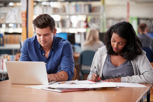 Preview: Two Mature Students Working On Laptop In College Library