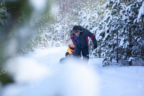 Preview: Dad and son on walking on path in woods. Father sledding a child in snowy winter day.