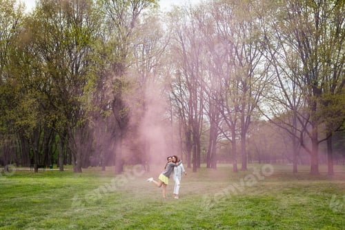 Preview: One girl hugging another standing in park