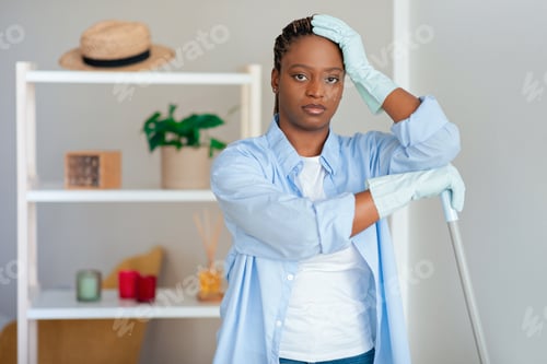 Preview: Upset black woman holding broom and touching her head