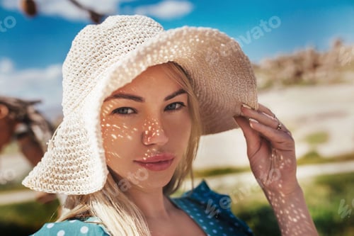 Preview: close-up portrait of a girl in a hat against the background of the landscape of cappadocia