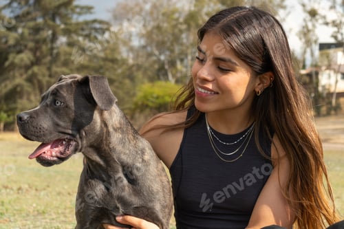 Vista previa: Mujer sonriente acariciando al perro Cane Corso