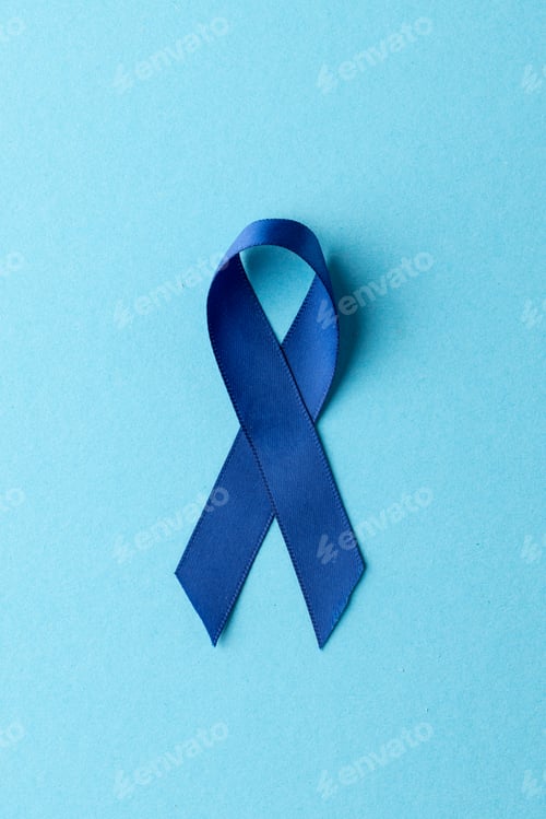 Preview: Vertical of blue ribbon for prostate cancer awareness, on blue background with copy space