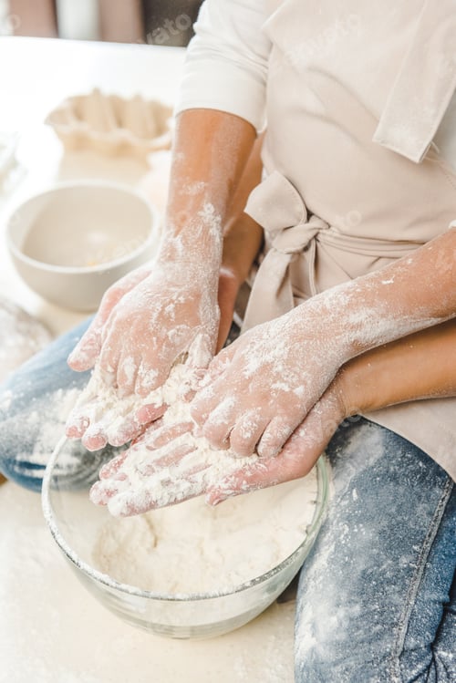 Preview: cropped image of mother and daughter holding each other hands with flour