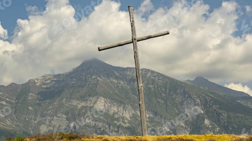 Preview: Closeup shot of a wooden cross with a beautiful nature scene behind