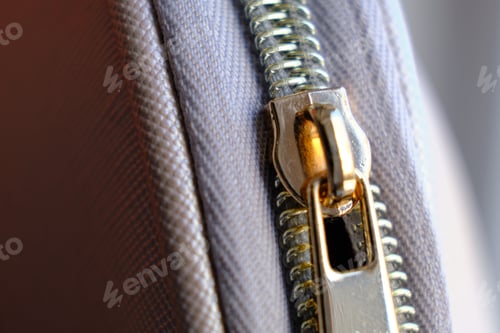 Preview: Selective focus, yellow metal zipper of a makeup bag or small purse macro pattern background
