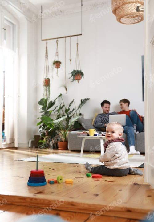 Preview: Parents sitting on couch, using laptop, while daughter is playing on the floor