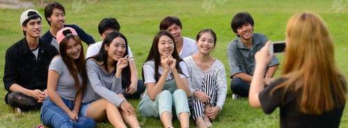 Preview: Happy young group of friends taking picture with phone together at the park