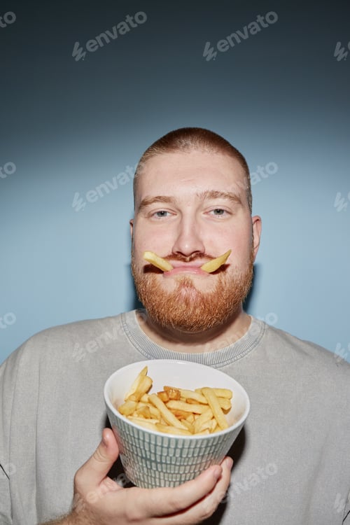 Preview: Portrait of Young Adult Man Holding French Fries and Making Funny Face