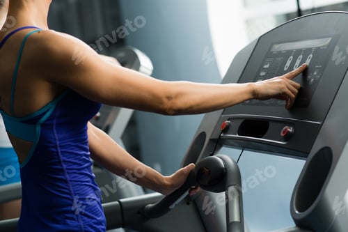 Preview: woman adjusts the treadmill